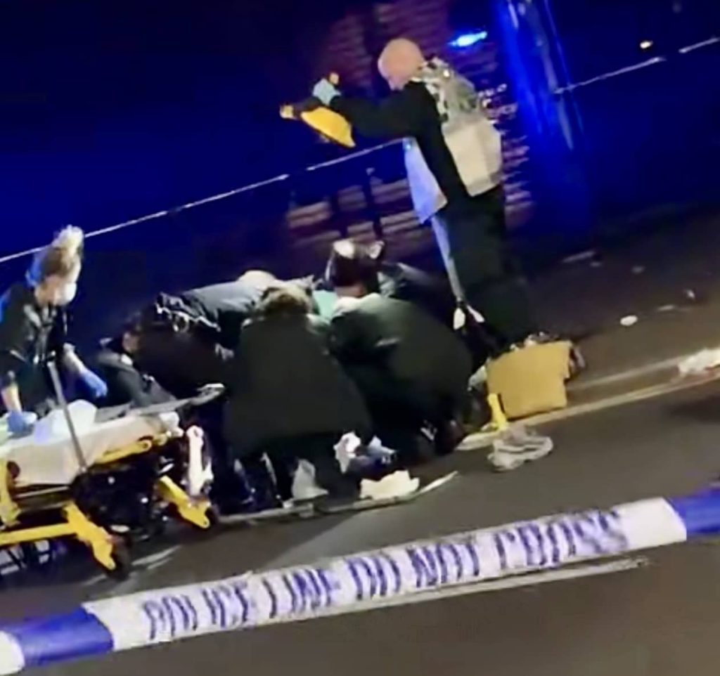 Paramedics Can Be Seen Working On A Person As Police Throw Hamilton Road  In Ilford Into Lockdown