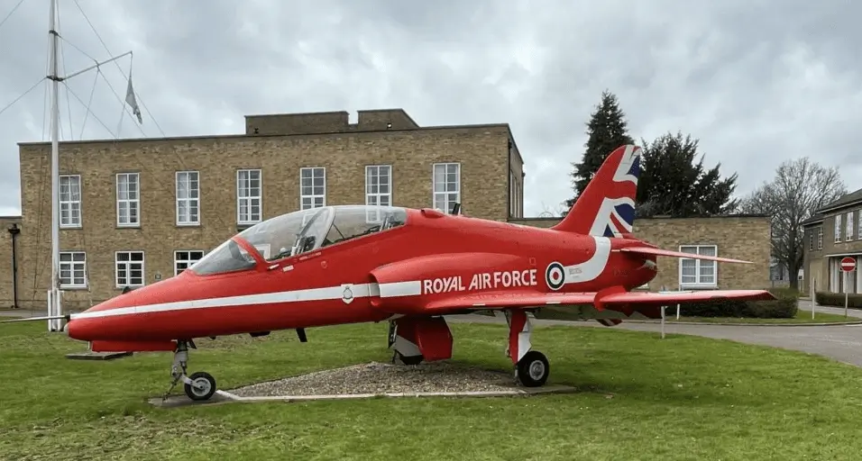 A former Red Arrows jet that guards the gates of RAF Scampton has gone up for auction