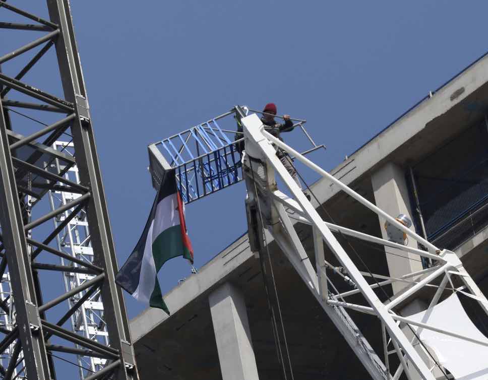 A 69-year-old Protester Has Mounted A Crane At A Nine Elms Building Site And Unfurled A Palestinian Flag As Police Try To Talk Him Down