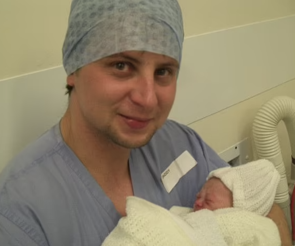 Healthcare professional holding newborn baby.