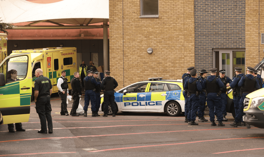 Emergency services at incident scene with ambulance and police.