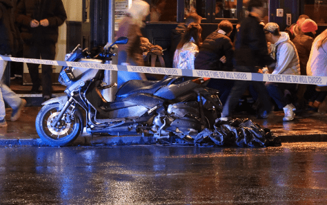 Motorcycle accident scene cordoned off at night.