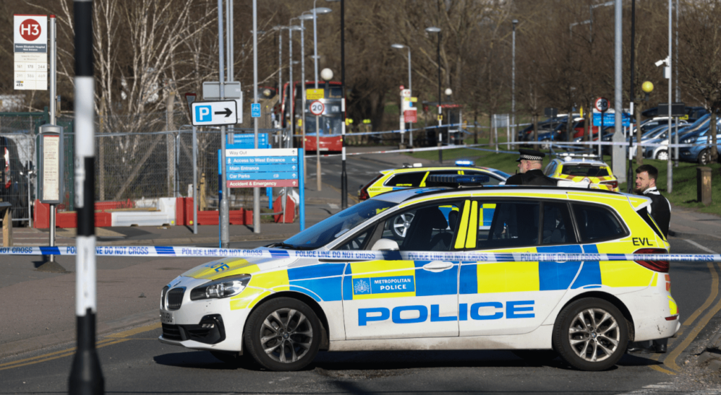 Police at UK crime scene with tape and vehicles.