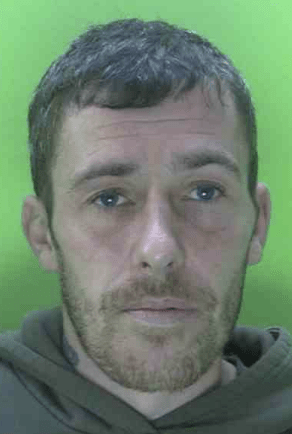 A violent offender who stabbed a man after storming into his flat has been jailed