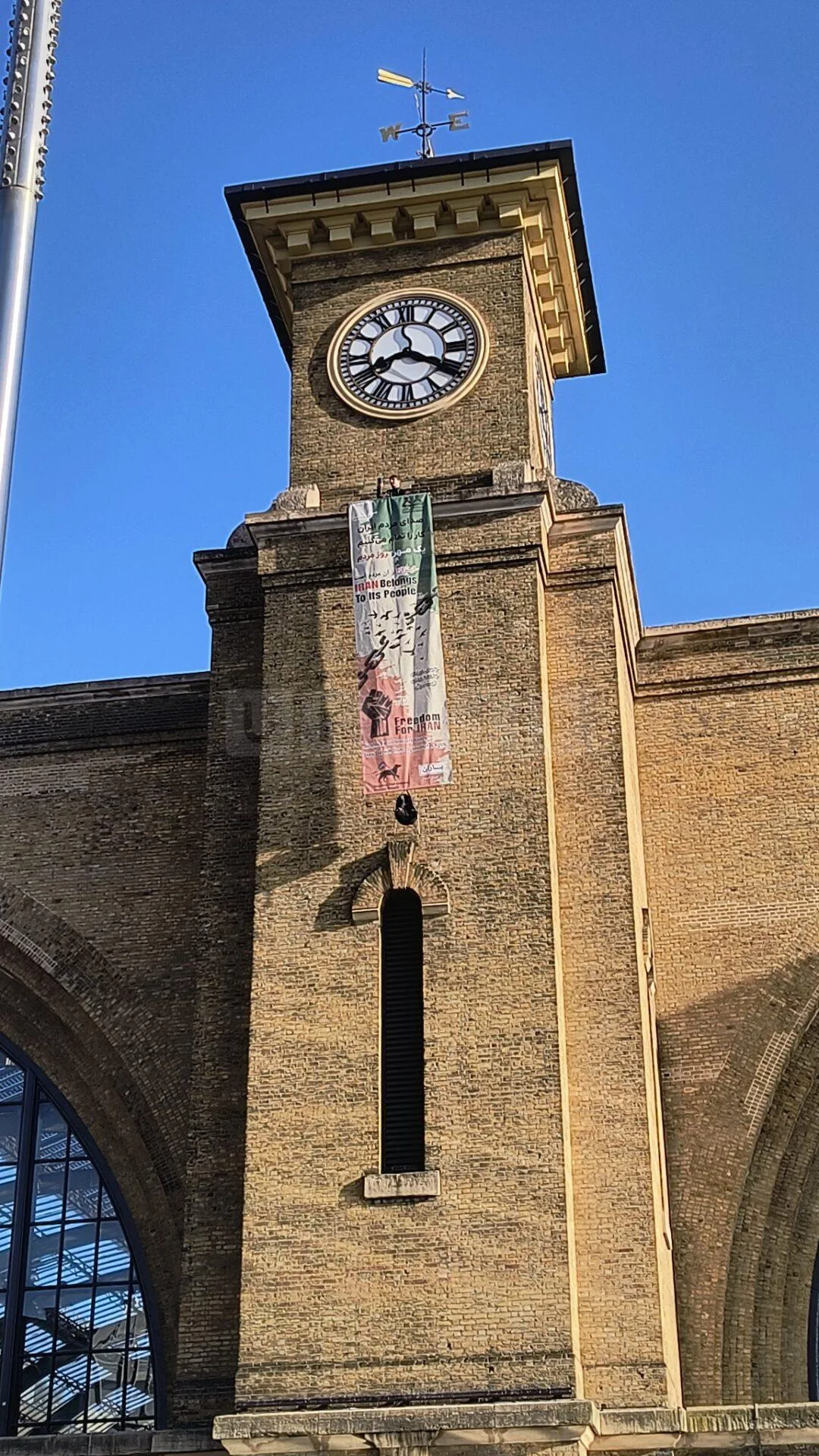 Protester and Pet Dog Scale King’s Cross Clock Tower in Anti-Iranian Government Demonstration