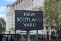 London, New Scotland Yard rotating sign outside Metropolitan Police Headquarters, near Westminster on the Thames embankment. Symbol of British law enforcement. Outdoors on an overcast summers day. May 4, 2021